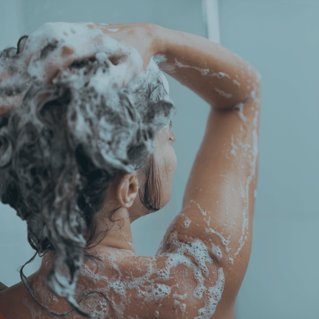 girl cleaning her hair with soap in the shower